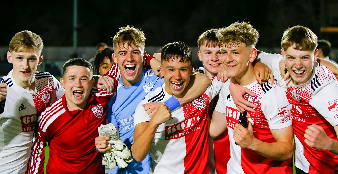 A group of Woking FC Academy players happy and celebrating a win
