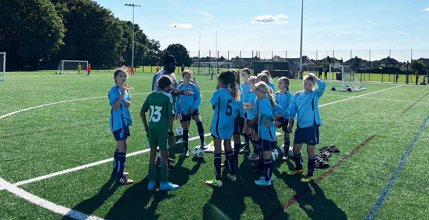 The manager of Woking FC Academy Girls U12s team gives a team talk to his players