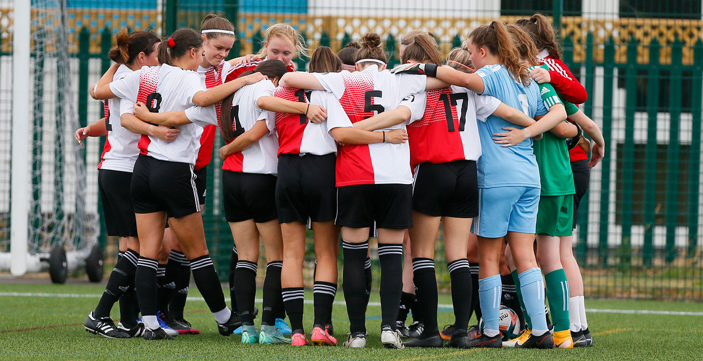 Woking FC Women team, arms around each other and preparing to play